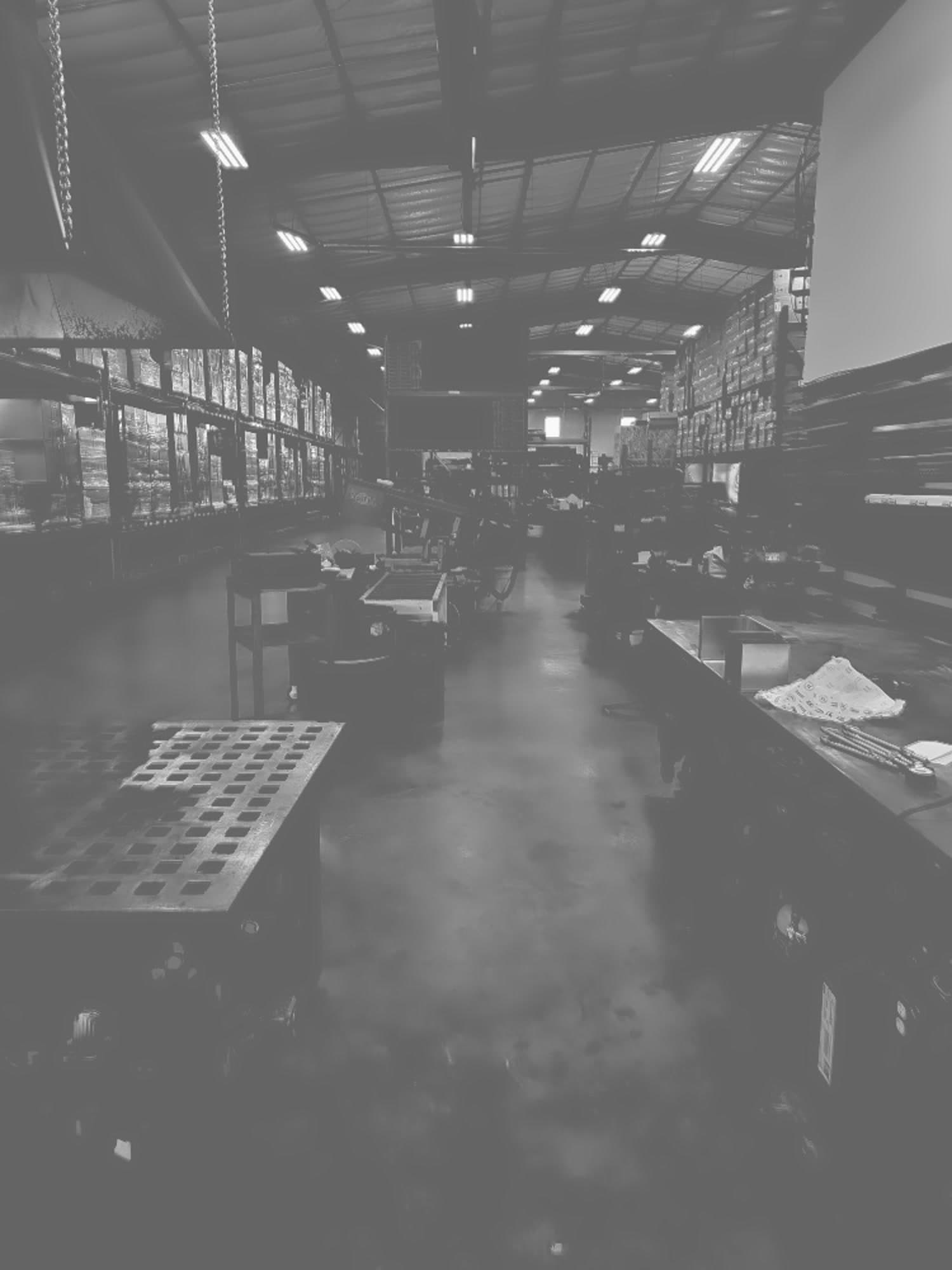 Shop floor interior — overhead lighting, storage racking, and fabrication benches